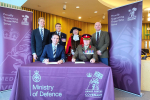 Cllr Tom Gracey signs the Armed Forces Covenant in front of the Mayor and MP